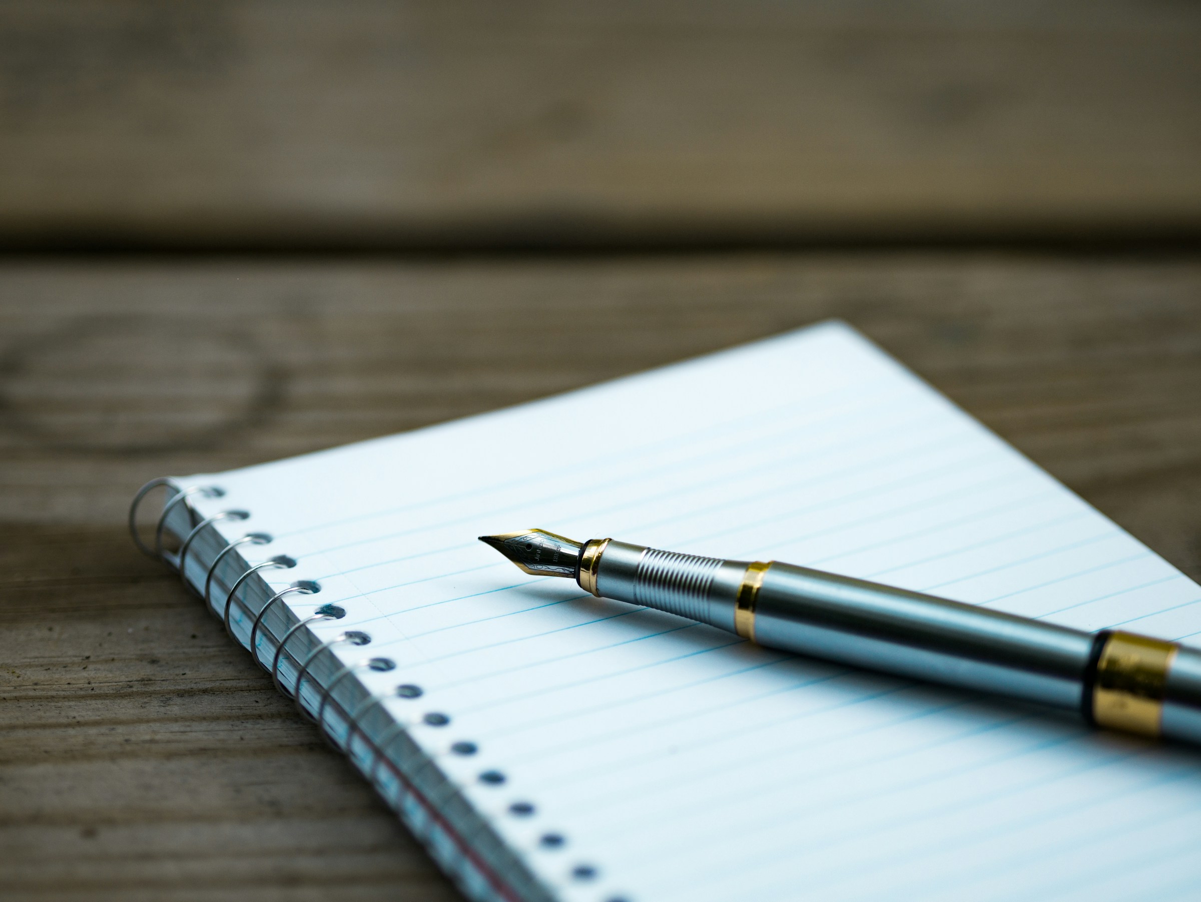 photograph of a writer's note pad and a pen